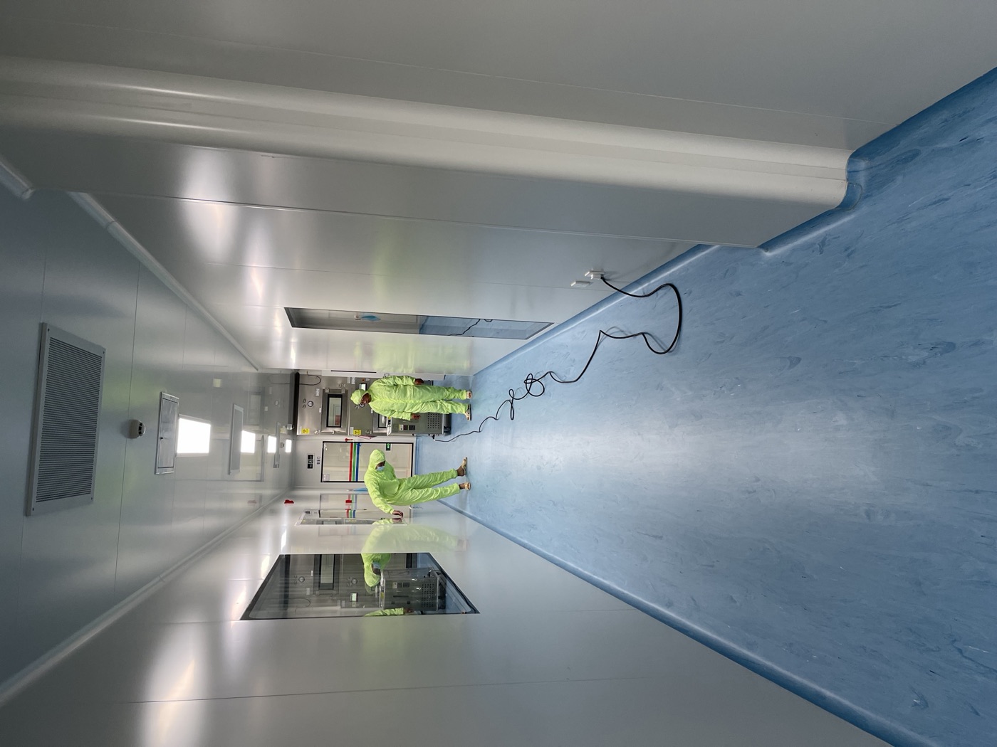 Personnel en combinaison de protection travaillant dans un couloir de salle propre